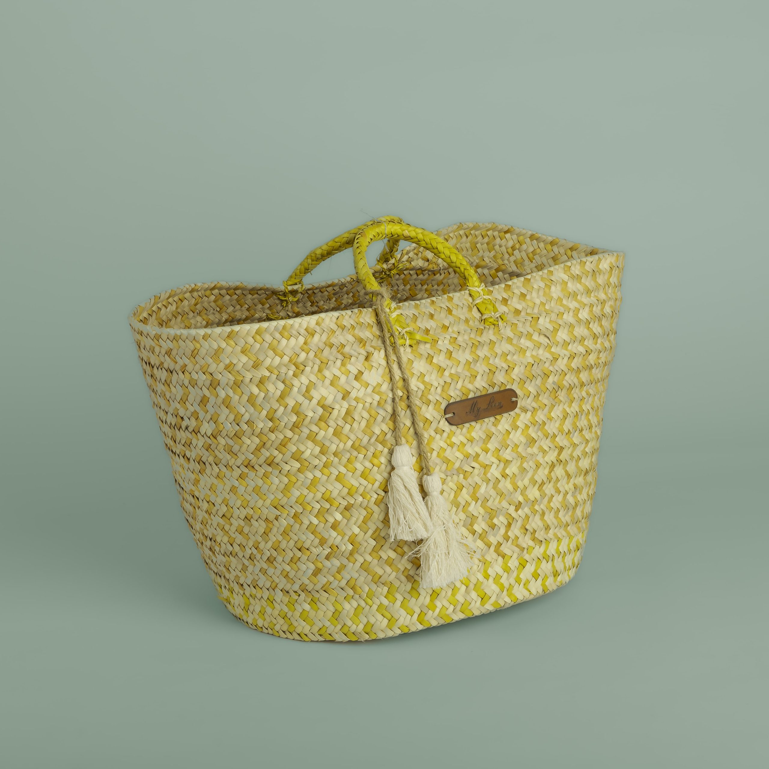 Panier en paille teinté avec poignées et pompons